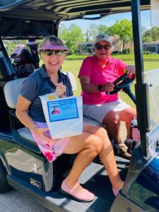 women in golf cart smiling